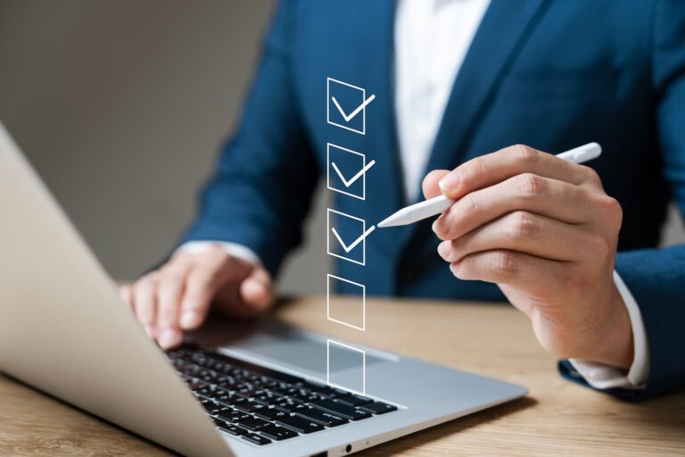 businessman using a laptop doing an online checklist survey