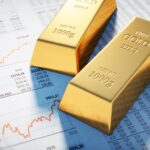 investing in gold: gold bars on stock market newspaper