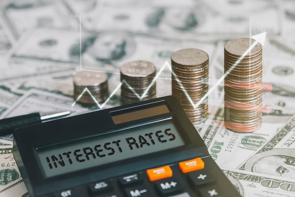 interest rate is on a calculator with a coin, a graph, and an arrow pointing up